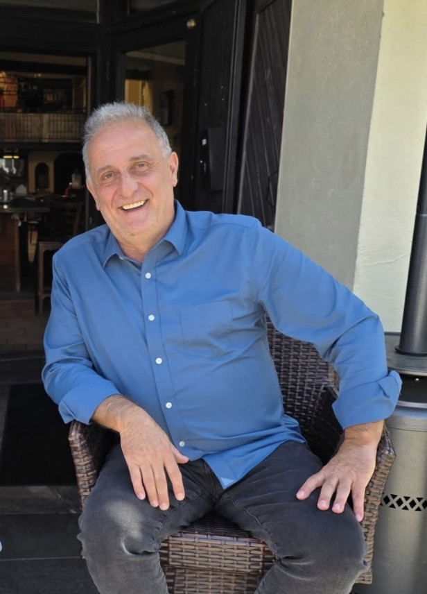 Chef Luigi Serafini seated in a wicker chair outside the Sapore dining room