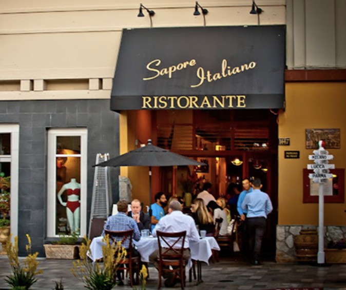 The Sapore storefront on Burlingame Avenue — a black awning reading Sapore Italiano Ristorante over white-clothed tables outside